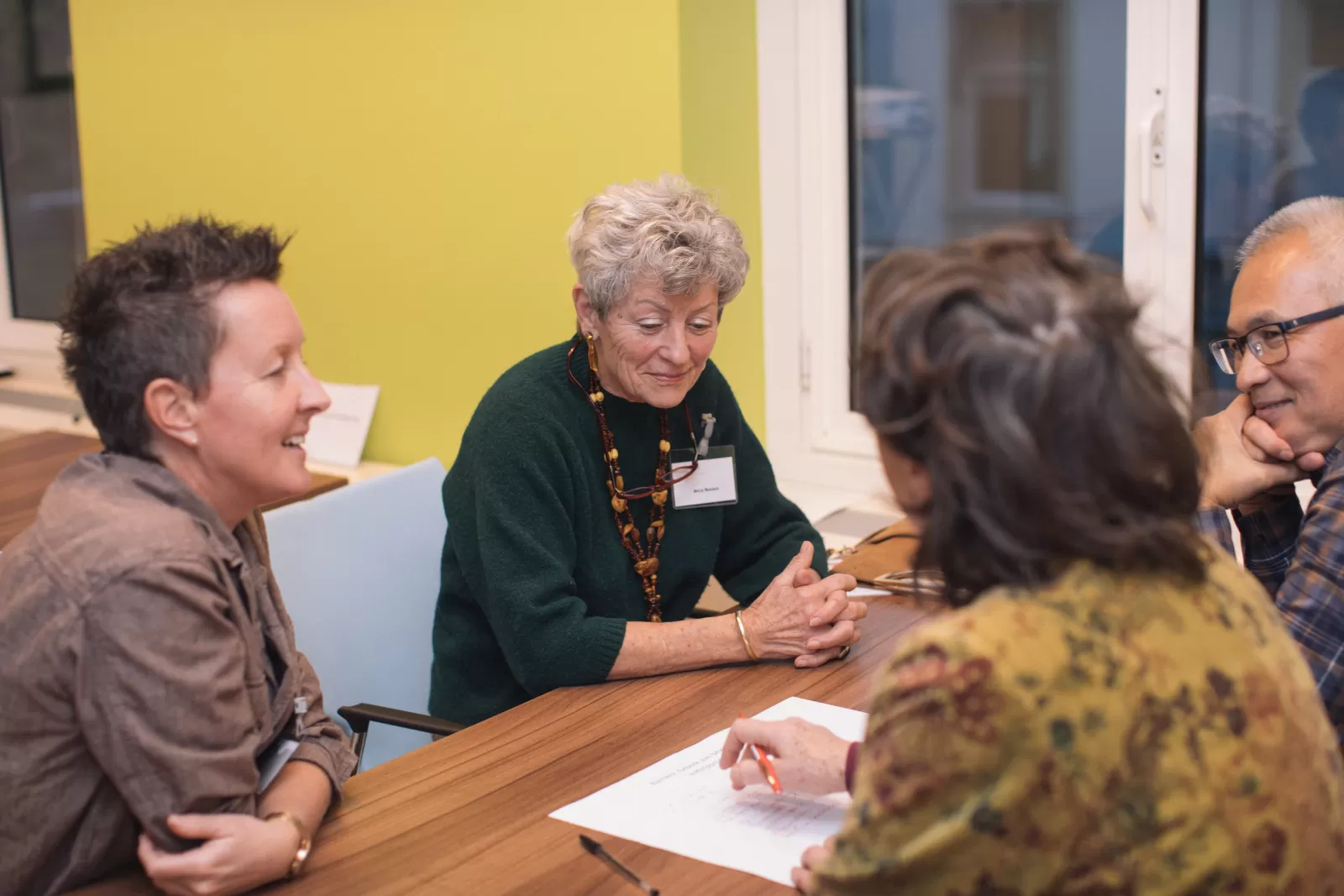 Vier mensen zijn in gesprek tijdens een workshop