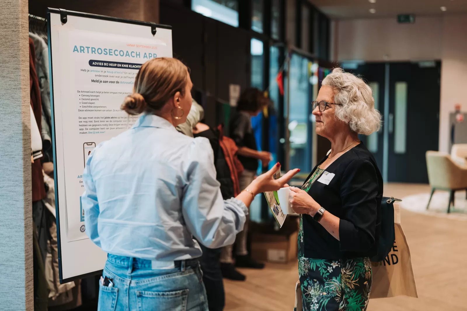 Bezoeker in gesprek met onderzoeker 